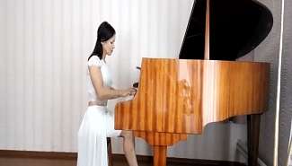 Олимпийская чемпионка по борьбе Ирина Мерлени играет на пианино в вечернем платье